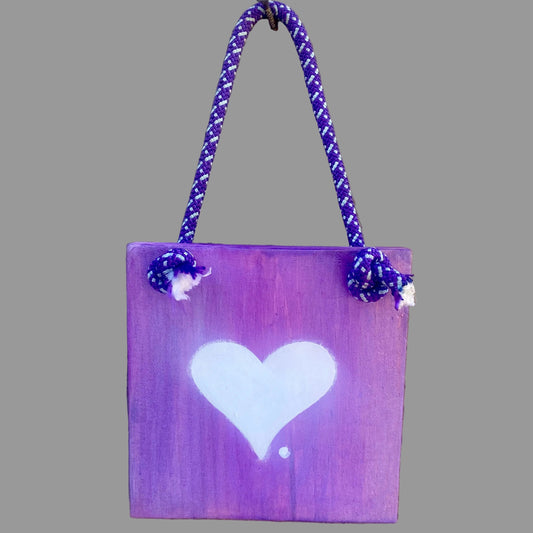 Small purple sign with a white heart and a blue and white braided rope